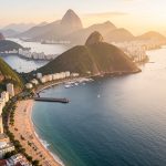Vue aérienne réaliste de Rio de Janeiro au lever du soleil, avec la baie de Guanabara, des montagnes verdoyantes et une plage urbaine.